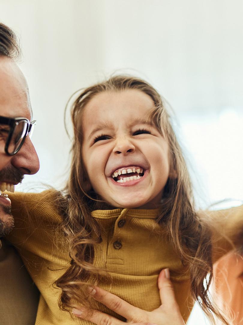 Cheerful girl having fun with her parents at home