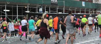 A group of runners in a marathon with a camera angle from behind them