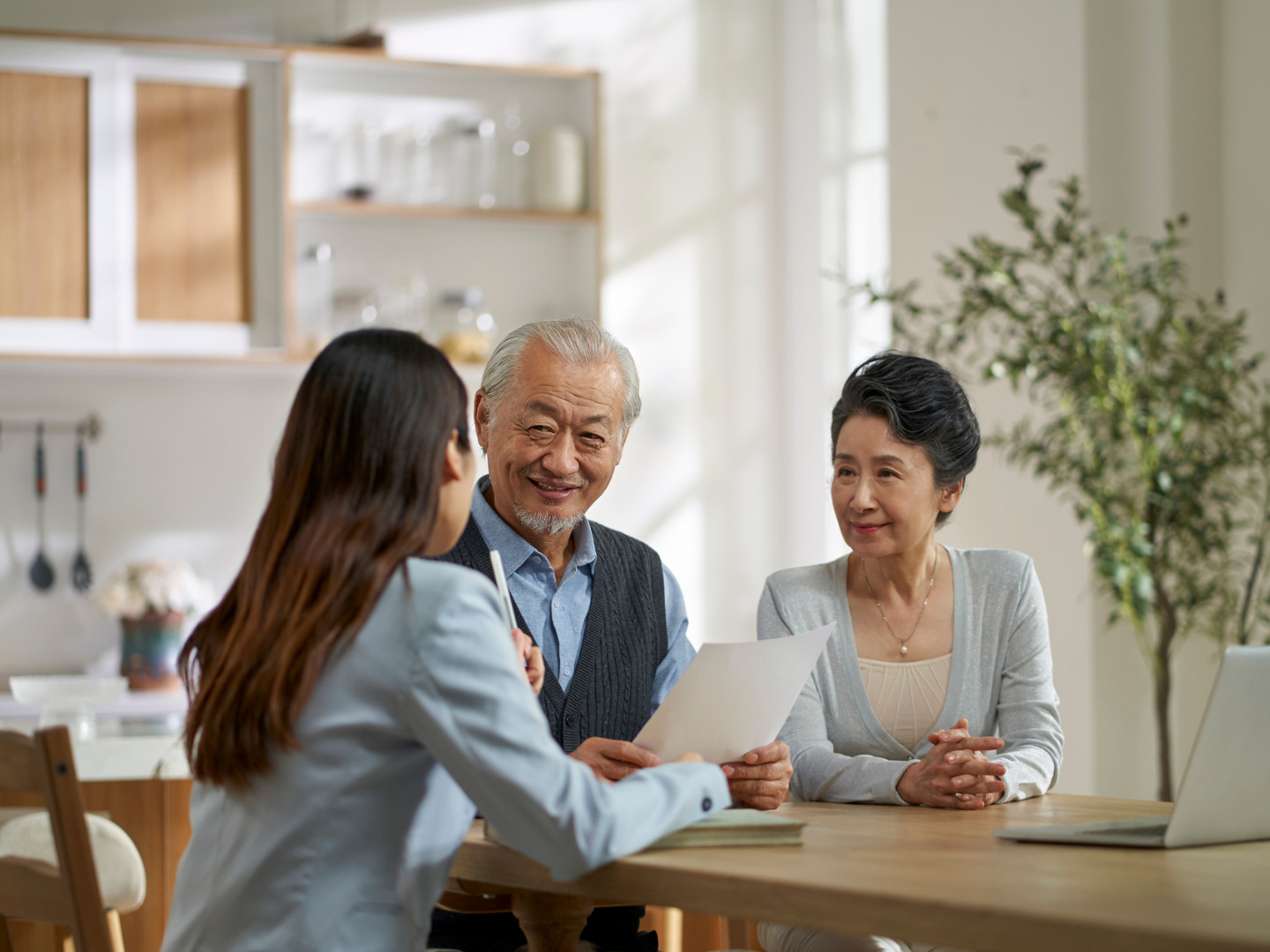 Two elderly people sitting with a woman discussing their will