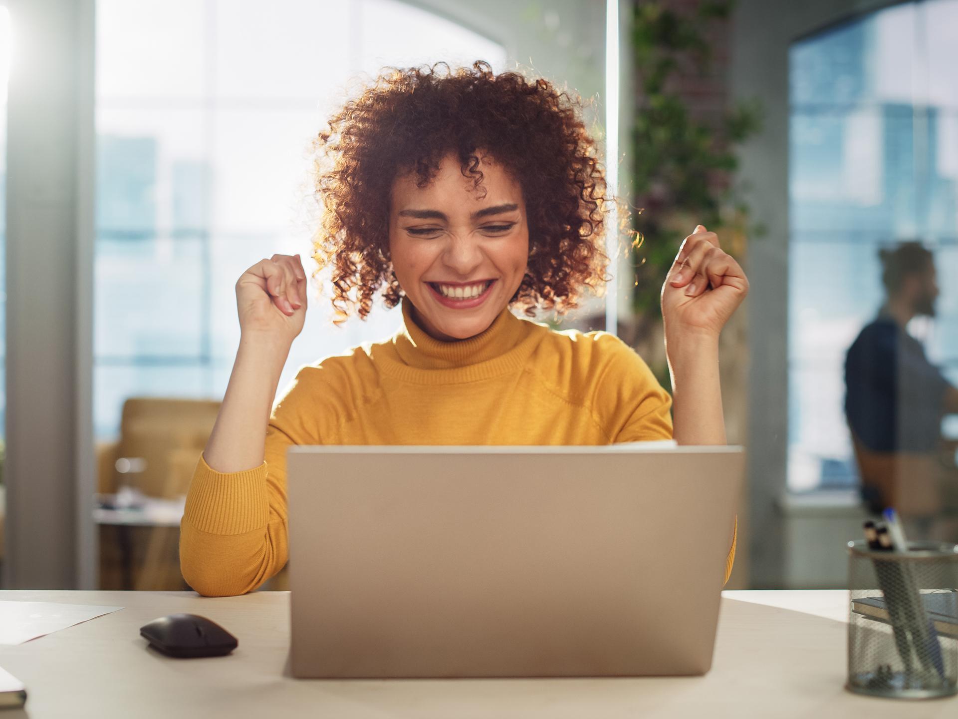 A photo of a happy woman on her laptop computer